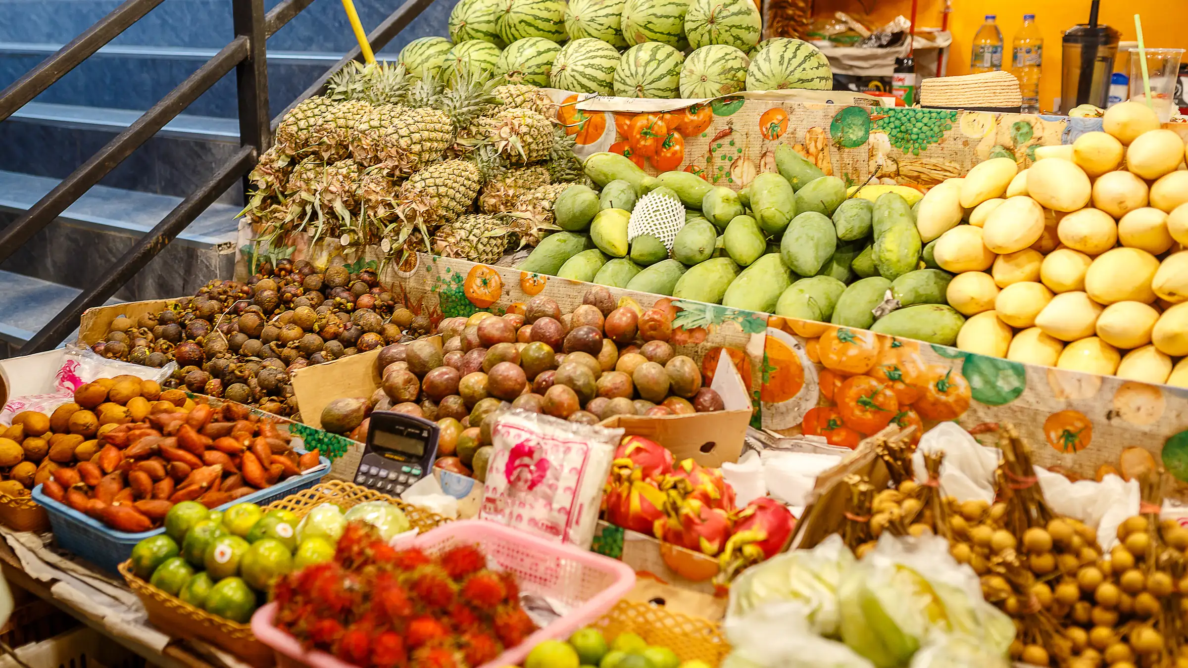 Un étal de marché thaïlandais chargé d’ananas, de pastèques, de mangues et d’autres fruits tropicaux