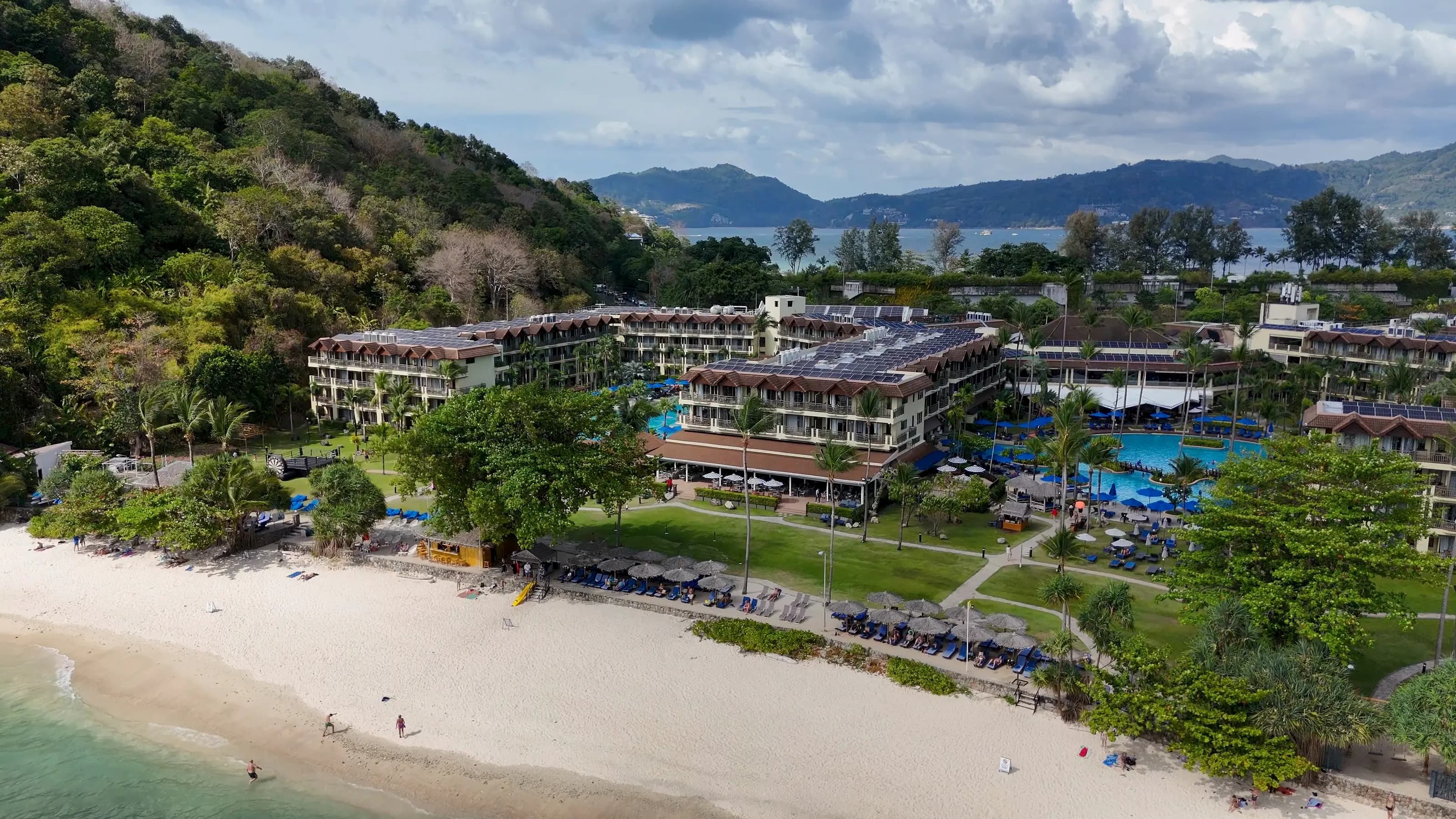 Vue aérienne d’une résidence en bord de plage à Phuket, avec jardins et piscines