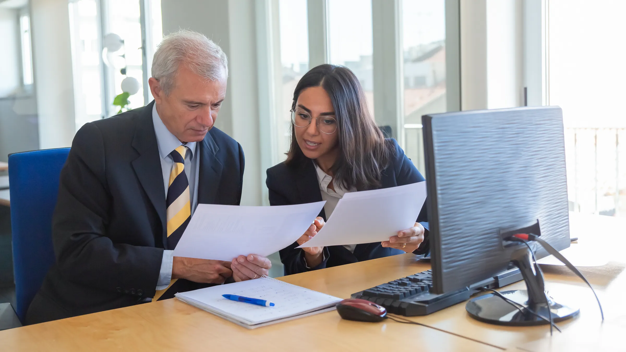 Conseillère juridique expliquant le détail d’un document à un client à son bureau