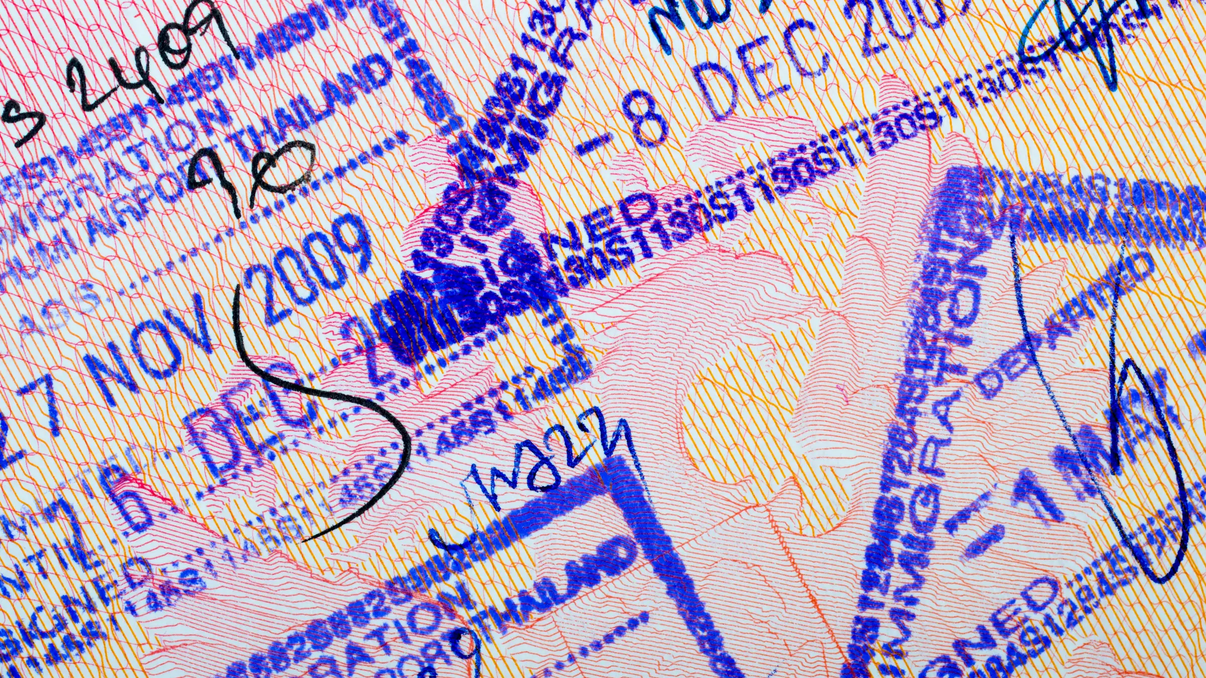 Gros plan sur une page de passeport couverte de tampons d’entrée et de sortie de l’immigration thaïlandaise